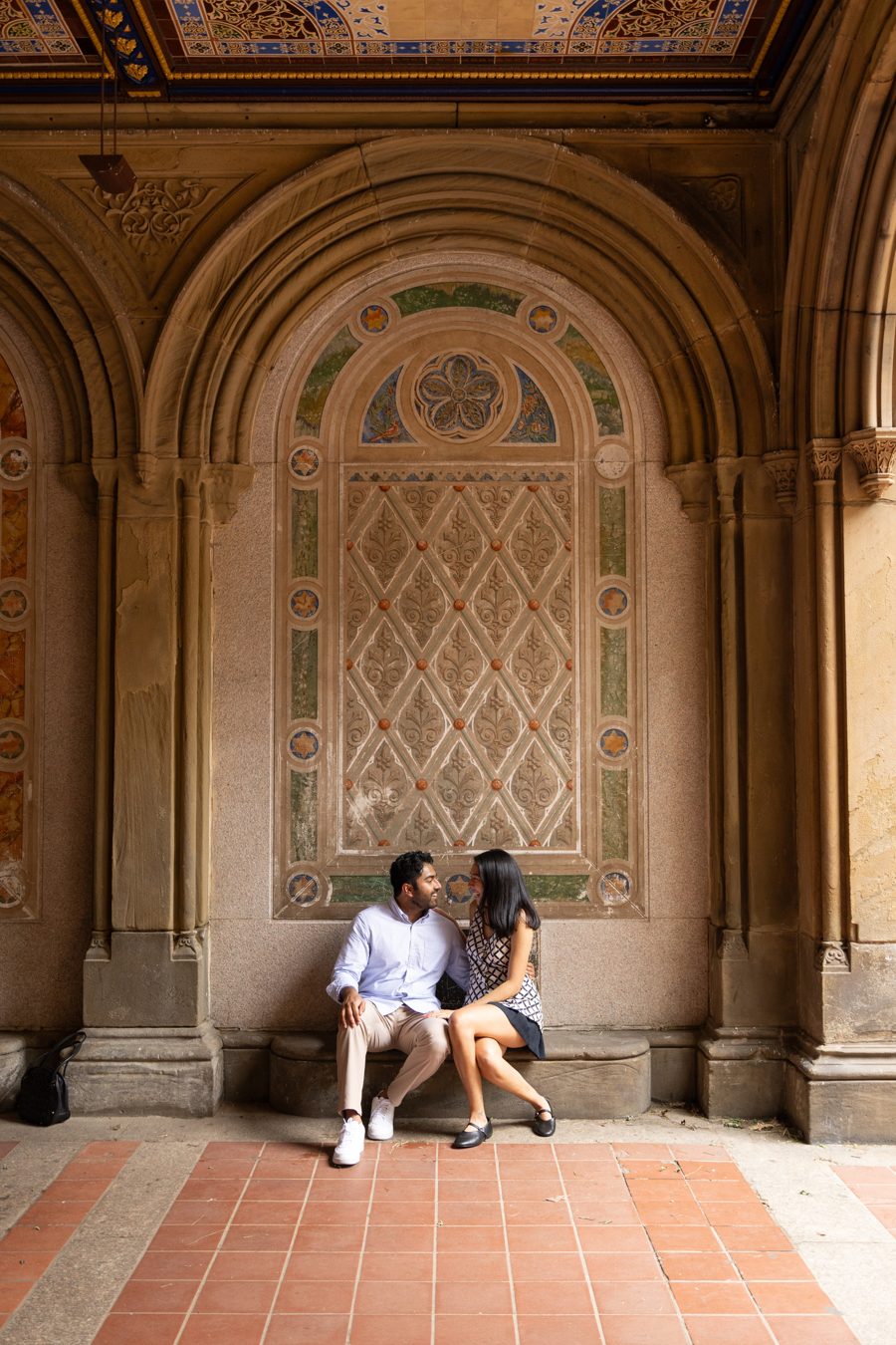 Akshay and Daniela sitting together beneath the tiled arches of Bethesda Terrace